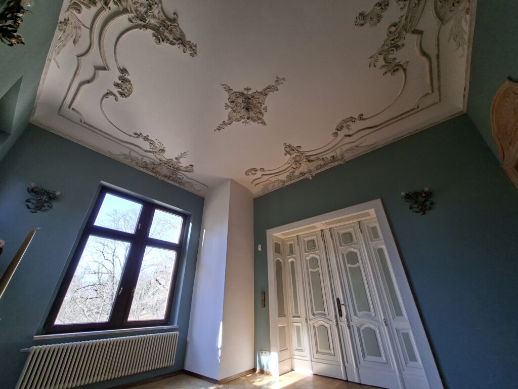 Salon im Stadtschloss Halle mit historischer Stuckdecke und hohen Fenstern